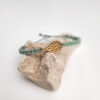 pulsera ameba mint hecha a mano con hilo de poliéster y pieza metálica con baño de oro. Ajustable
