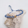 pulsera estrella azul hecha a mano con hilo de poliéster formando una espiral. En el centro lleva una pieza en forma de estrella con baño de oro.