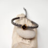 pulsera cruz cuadrada gris hecha a mano con poliéster encerado y pieza central con baño de oro y cierre ajustable con nudo corredero