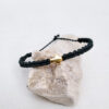 pulsera cruz verde inglés hecha a mano con poliéster encerado y pieza central con baño de oro. cierre ajustable mediante nudo coredero