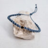 pulsera hecha a mano con poliéster encerado y con una pieza en forma de estrella, con baño de oro. Cierre ajustable