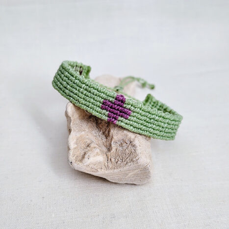 pulsera cruz nudos verde, hecha a mano con hilo de poliéster encerado resistente al agua y nudo corredero ajustable. cruz central en color morado